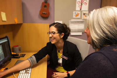 A consultant helping a librarian at a computer